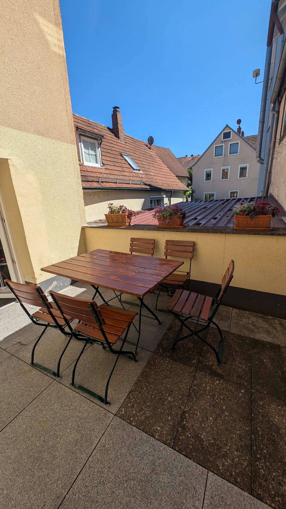 Große Terrasse mit Holztisch und Stühlen